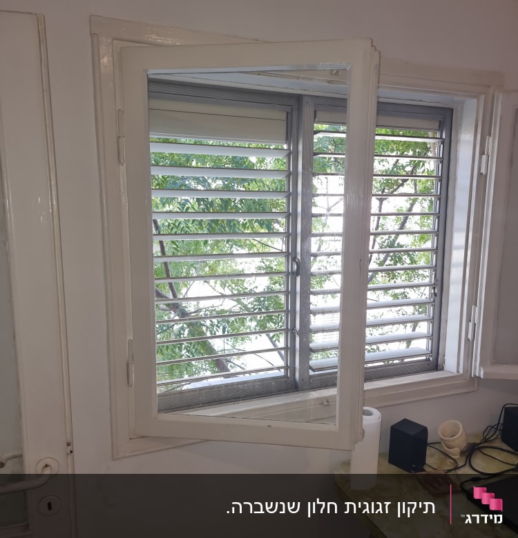 חלון זכוכית פתוח עם תריסים